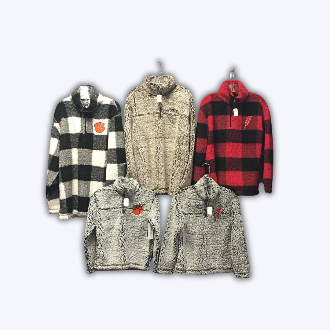 A group of jackets are hanging on a rack on a white background.