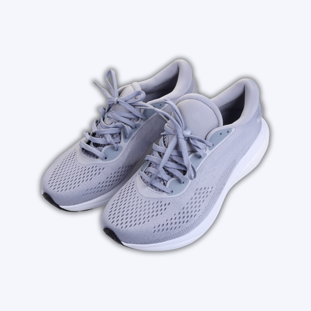 A pair of grey and white sneakers on a white background