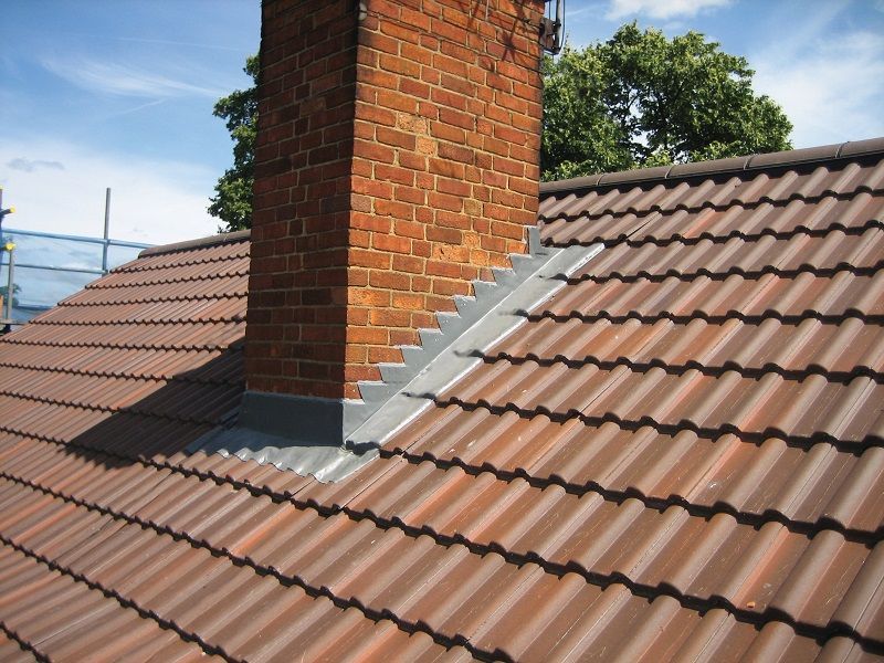 A brick chimney on top of a tiled roof