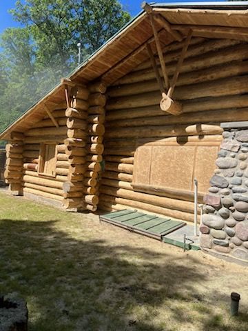 A log cabin is sitting on top of a lush green field.