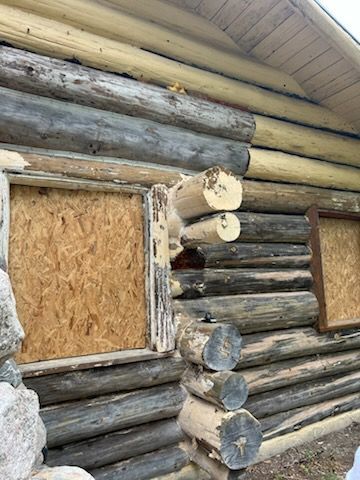 A log cabin with a hole in the side of it.