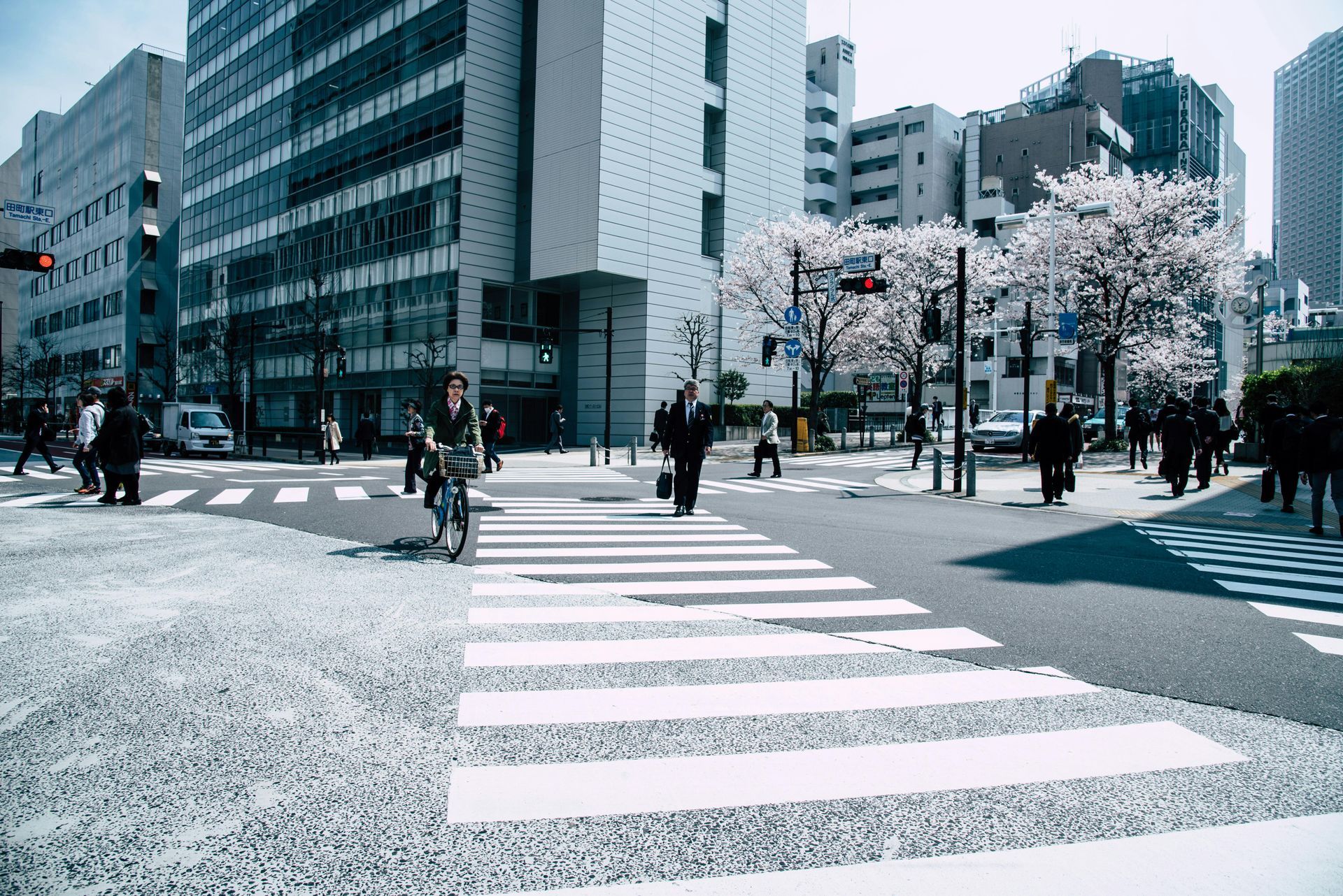 A group of people are crossing a street in a city.