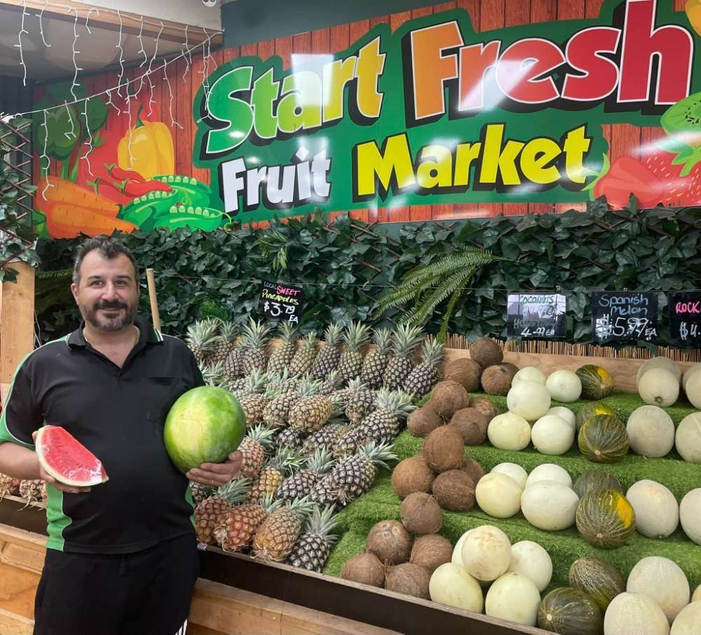 A Man Is Holding A Watermelon — Start Fresh Fruit Market in Bundaberg Central QLD