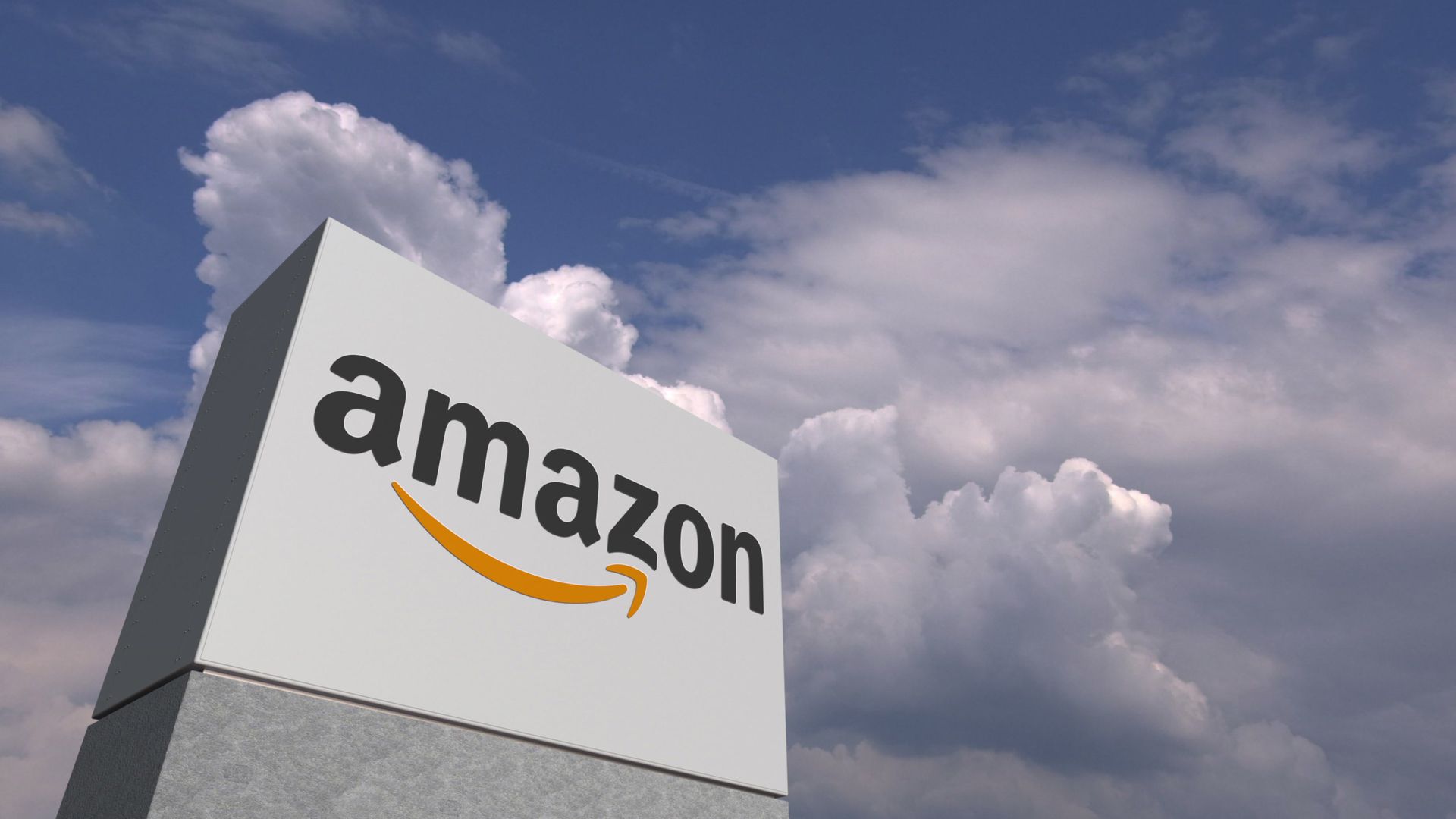 An amazon sign is against a cloudy sky.