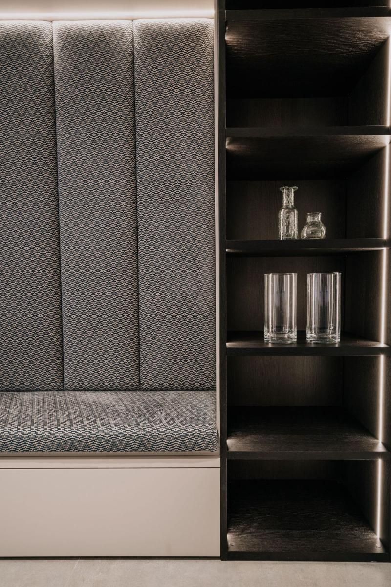 Uno scaffale con due bicchieri accanto a un divano.