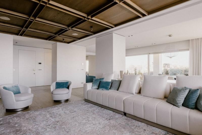 Un soggiorno con divano, sedie e tappeto.