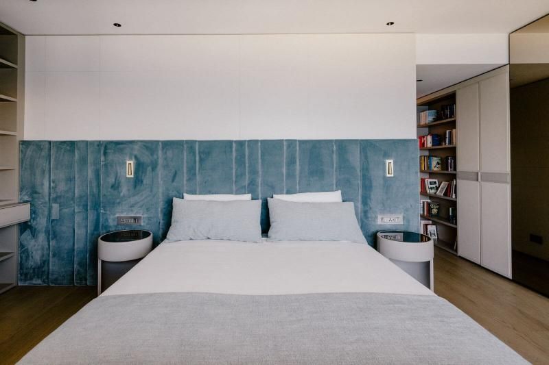 Una camera da letto con letto, comodini e libreria.