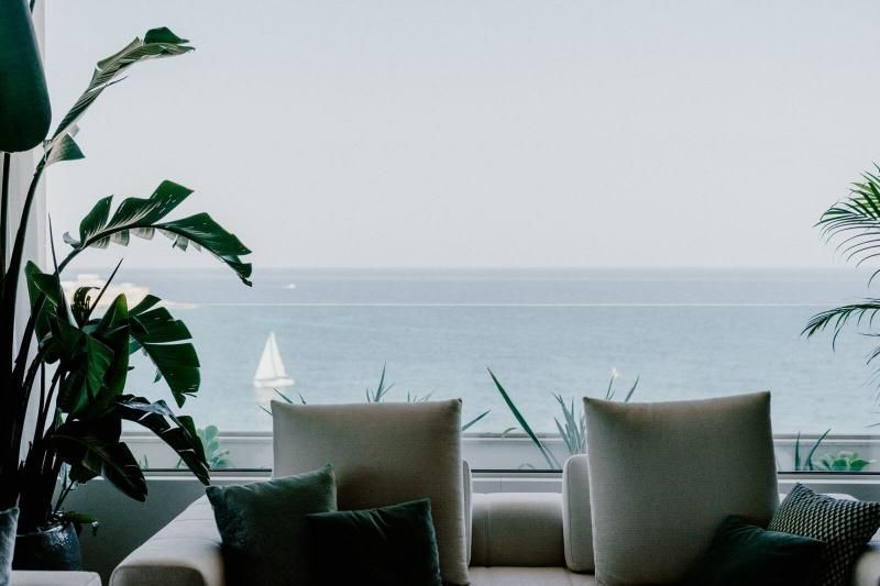Un soggiorno con divano e due sedie con vista sull'oceano.