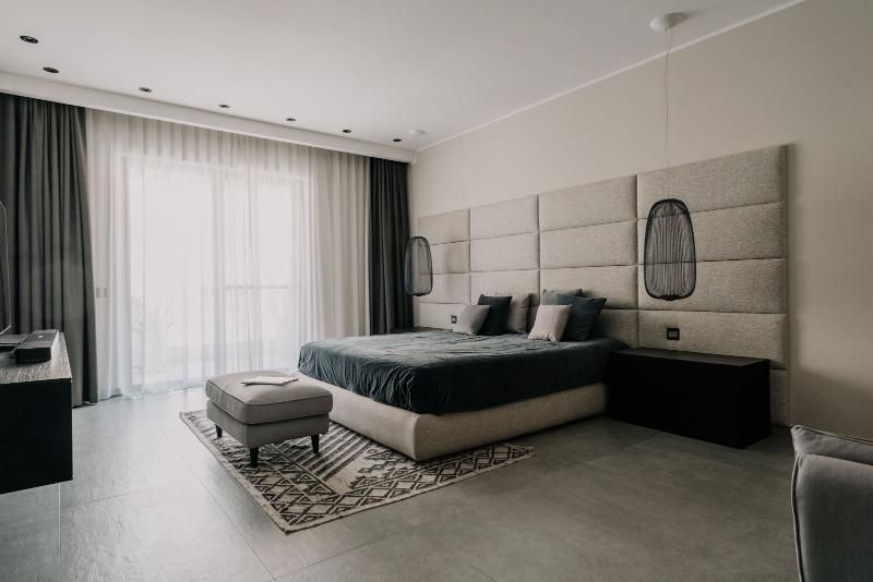 C'è un grande letto al centro della stanza con le nostre tende alle finestre