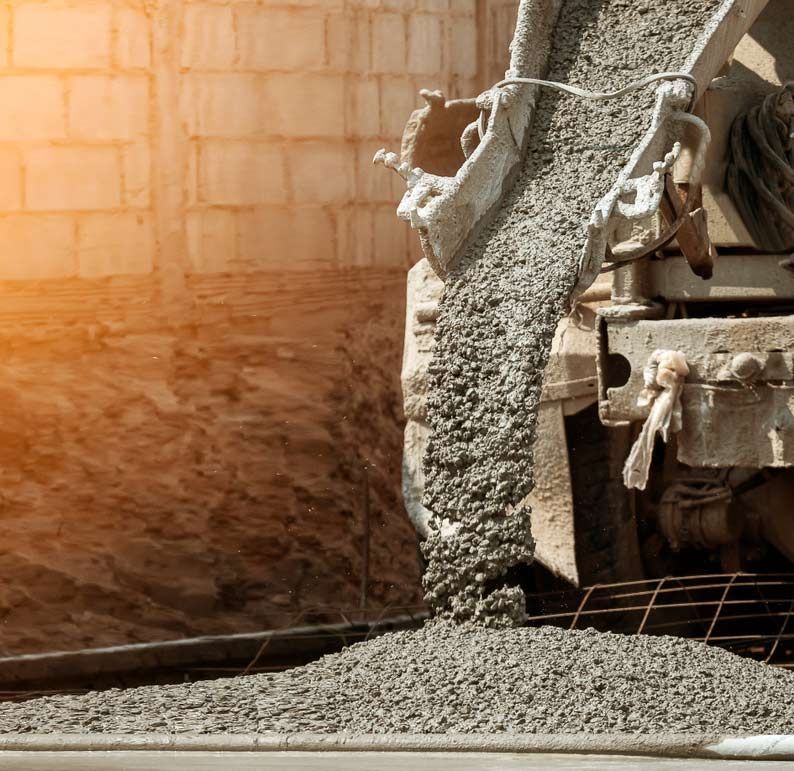 A Concrete Pump Is Pouring Concrete Into A Pile Of Gravel — Ingham Concrete–Icon in Ingham, QLD