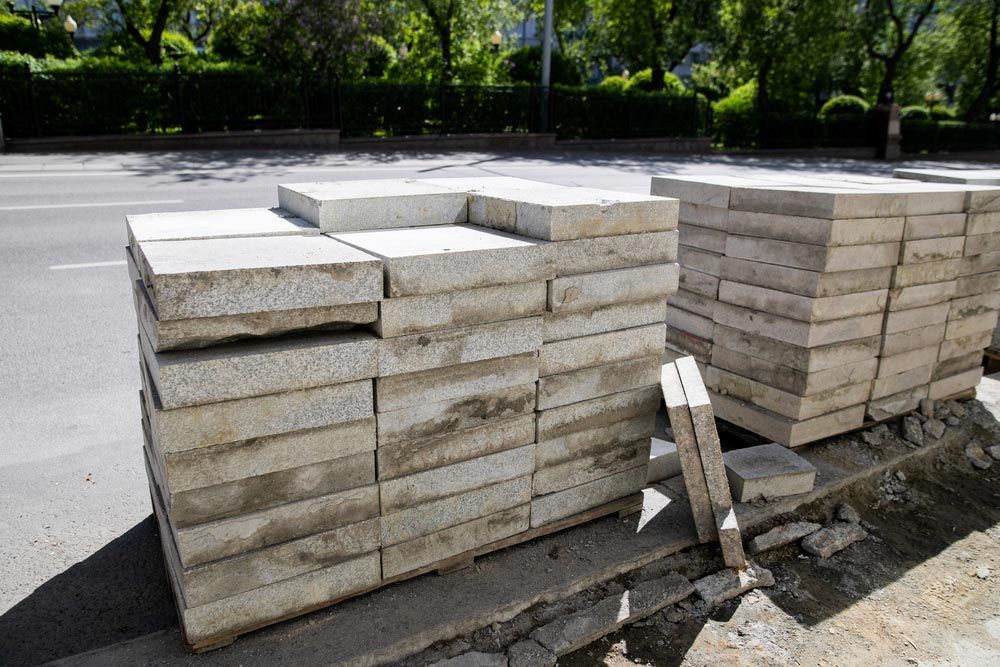 A Pile Of Concrete Blocks Is Stacked On The Side Of The Road — Ingham Concrete–Icon in Cardwell, QLD