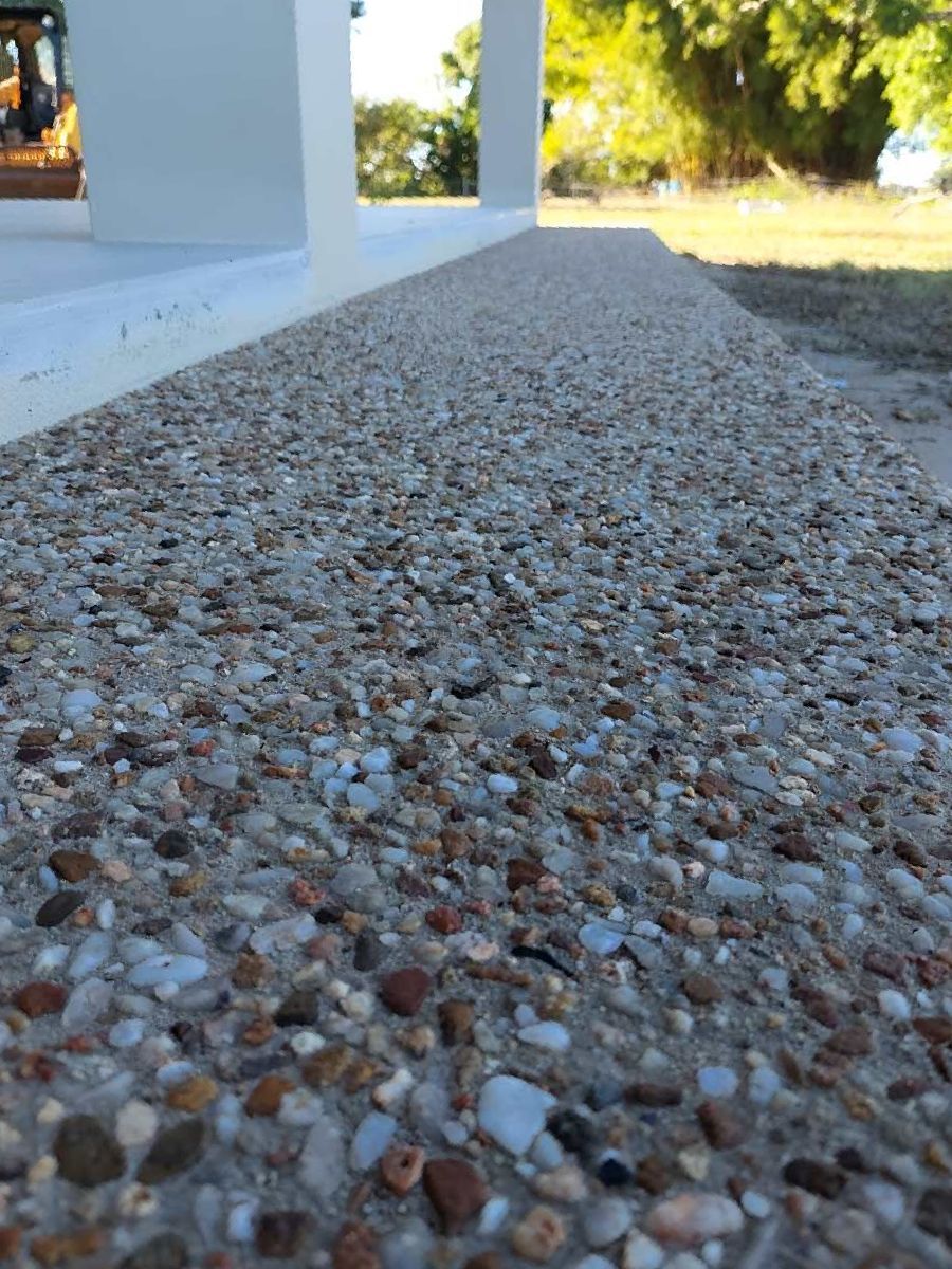 A Close Up Of A Gravel Driveway With A Bulldozer In The Background — Ingham Concrete–Icon in Ingham, QLD