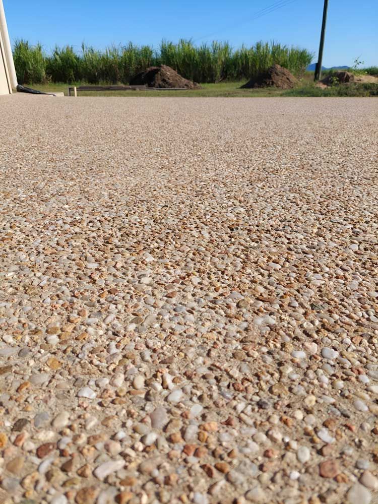 Concrete Gravel Driveway With Trees In The Background — Ingham Concrete–Icon in Cardwell, QLD
