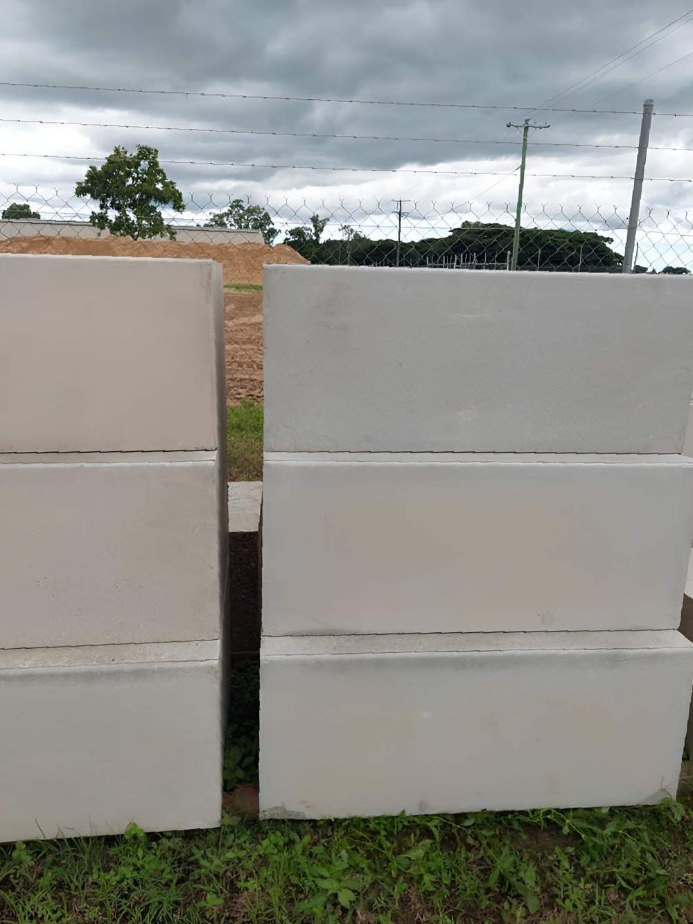 A Stack Of Concrete Blocks Sitting On Top Of Each Other In A Field — Ingham Concrete–Icon in Ingham, QLD