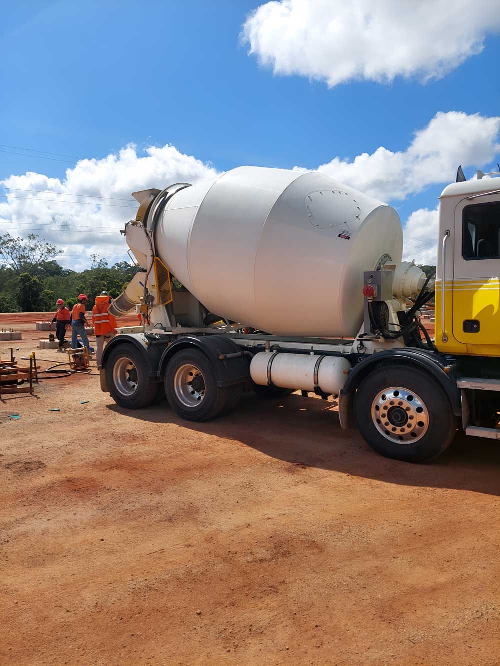 A Concrete Mixer Truck Is Parked In A Dirt Field — Ingham Concrete–Icon in Ingham, QLD