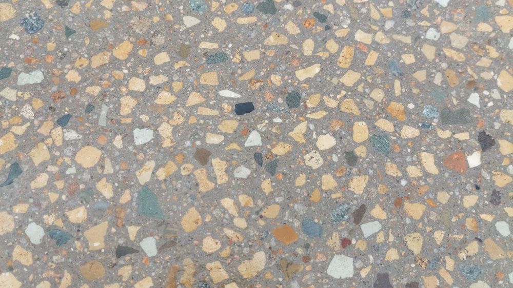 A Close Up Of A Concrete Surface With A Lot Of Small Rocks — Ingham Concrete–Icon in Ingham, QLD