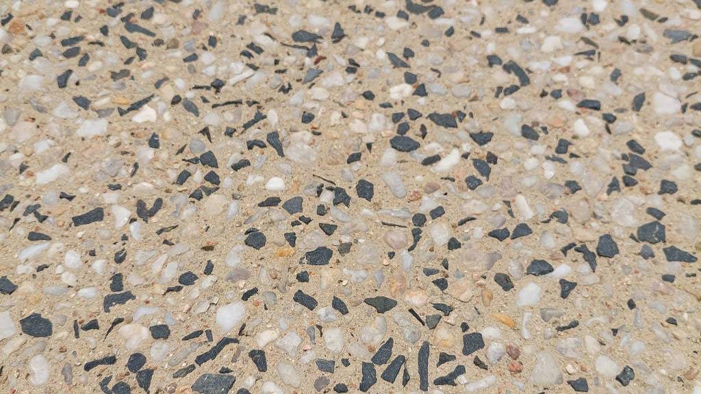 A Close Up Of A Concrete Surface With A Lot Of Small Rocks On It — Ingham Concrete–Icon in Cardwell, QLD