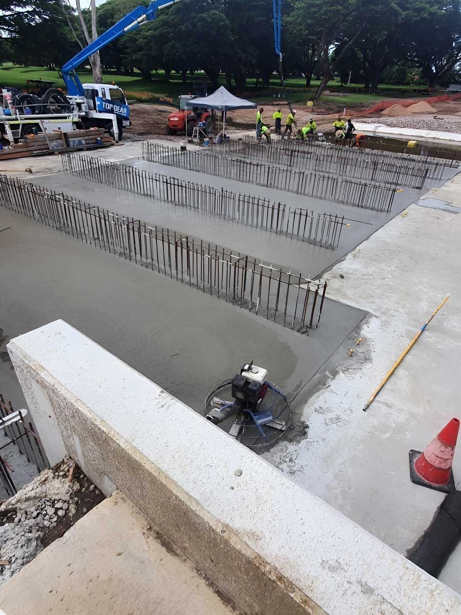 A Group Of Construction Workers Are Putting Ready Mix Concrete — Ingham Concrete–Icon in Ingham, QLD