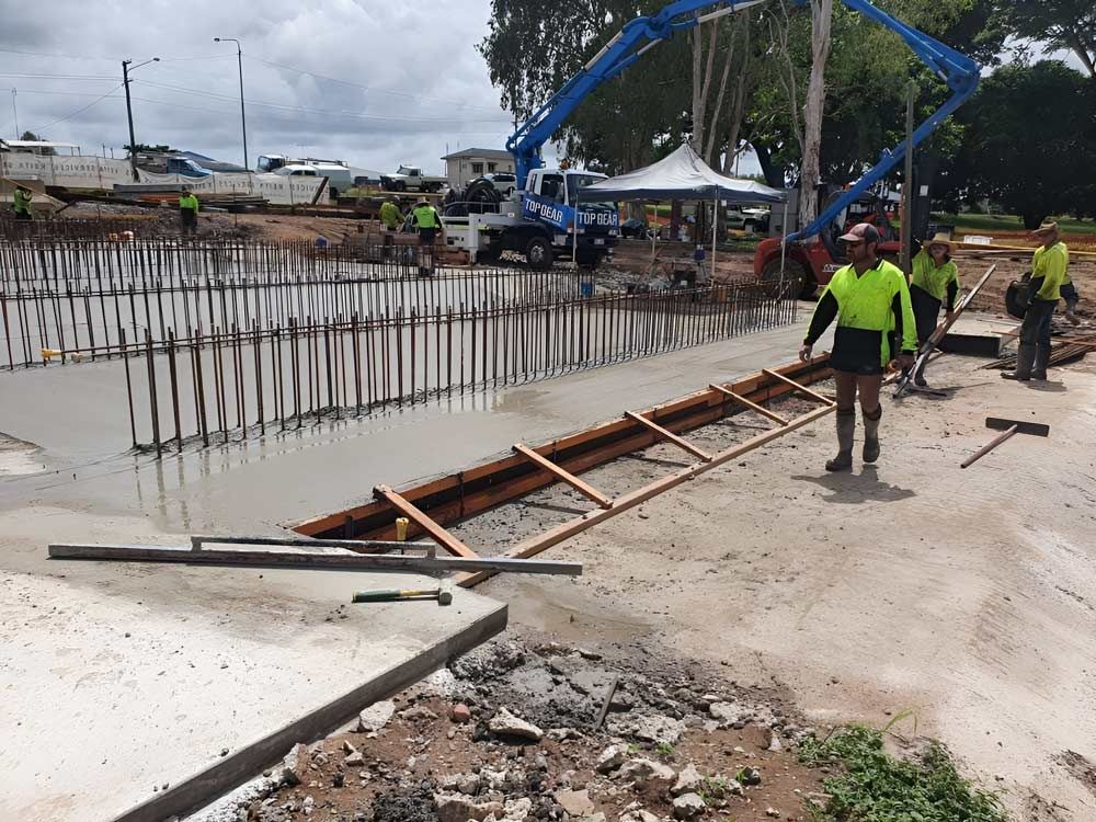Building Is Under Construction, With Workers Pouring Concrete — Ingham Concrete–Icon in Ingham, QLD