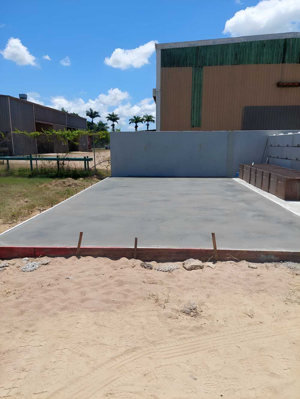 A Concrete Driveway Is Being Built In Front Of A Building — Ingham Concrete–Icon in Cardwell, QLD
