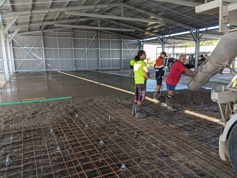 A Group Of Construction Workers Are Pouring Concrete Into A Building — Ingham Concrete–Icon in Ingham, QLD