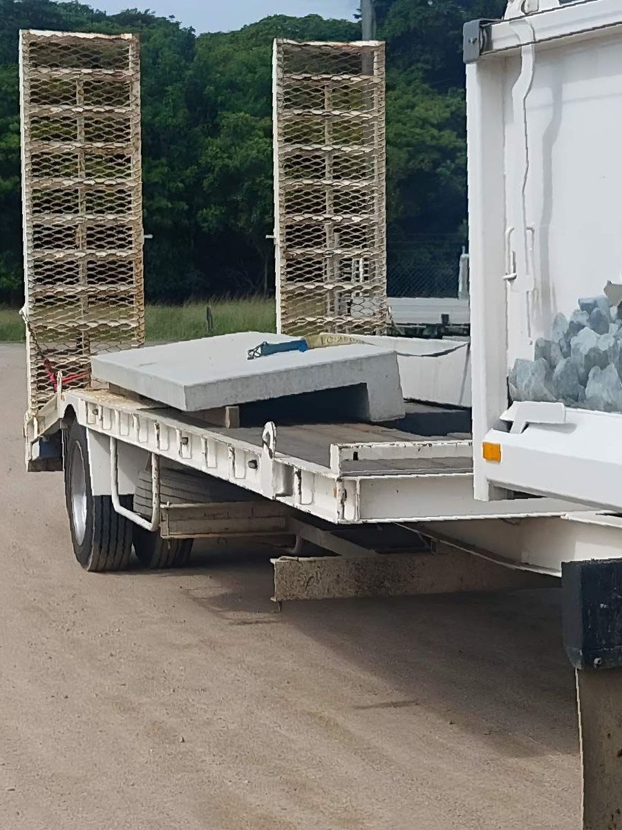 A White Truck With A Trailer Attached With Concrete Panel — Ingham Concrete–Icon in Ingham, QLD