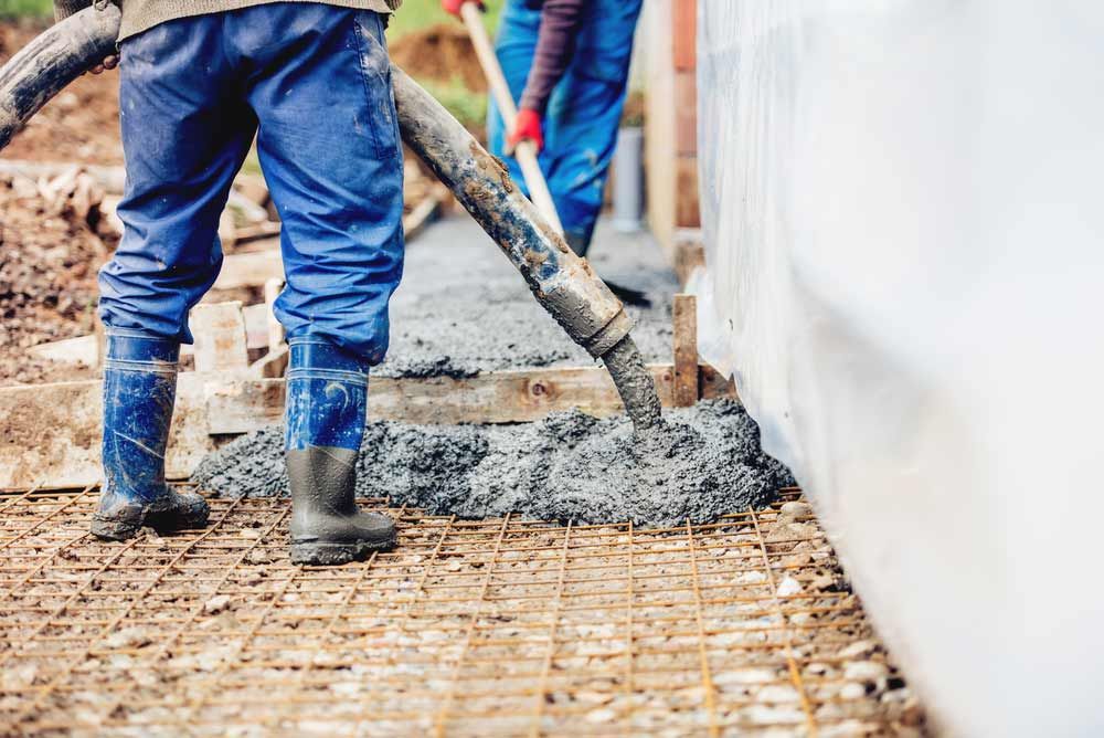 Worker Laying  Concrete With An Automatic Pump — Ingham Concrete–Icon in Cardwell, QLD
