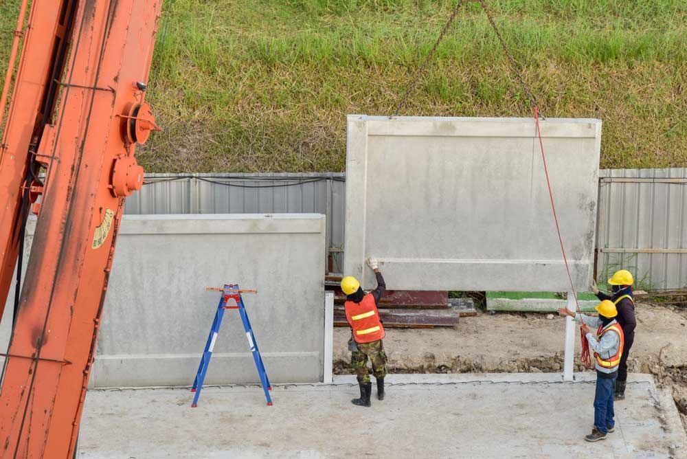 A Group Of Construction Workers Are Working On A Concrete Wall Panel — Ingham Concrete–Icon in Ingham, QLD