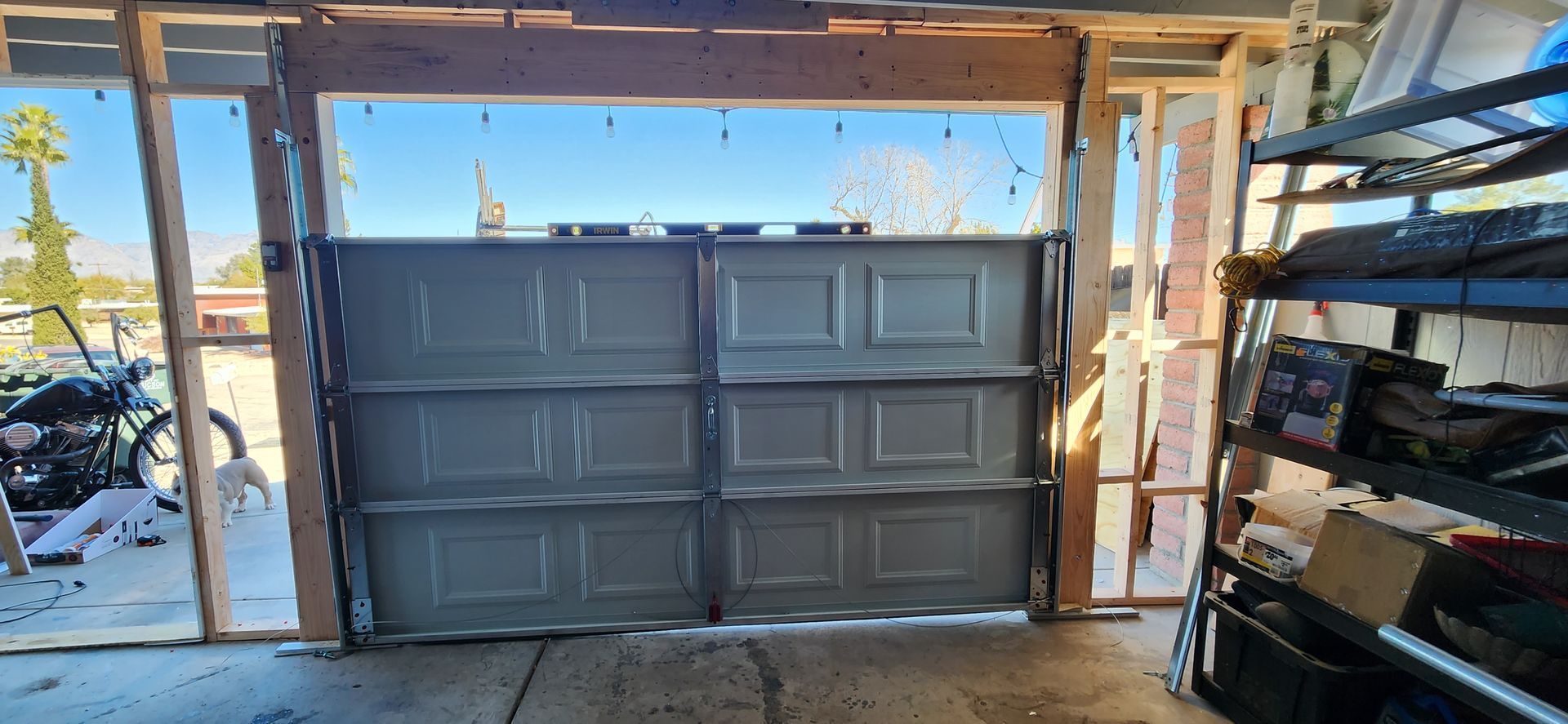 A garage door is open in a garage under construction.