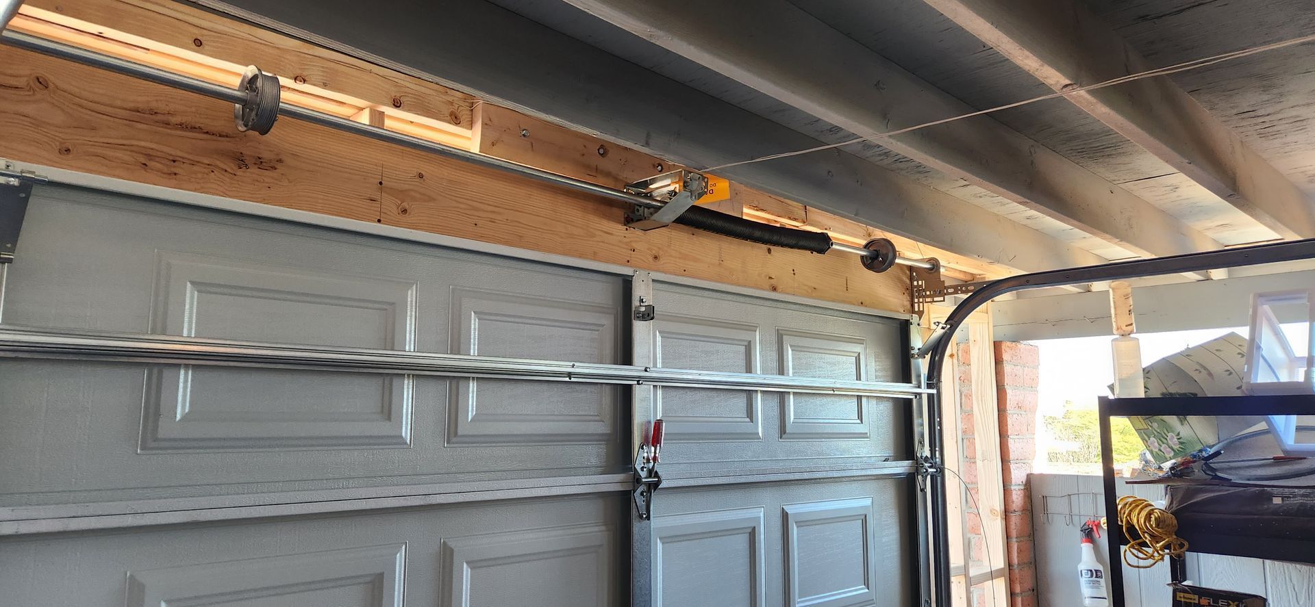 A garage door with a motor attached to it is open.