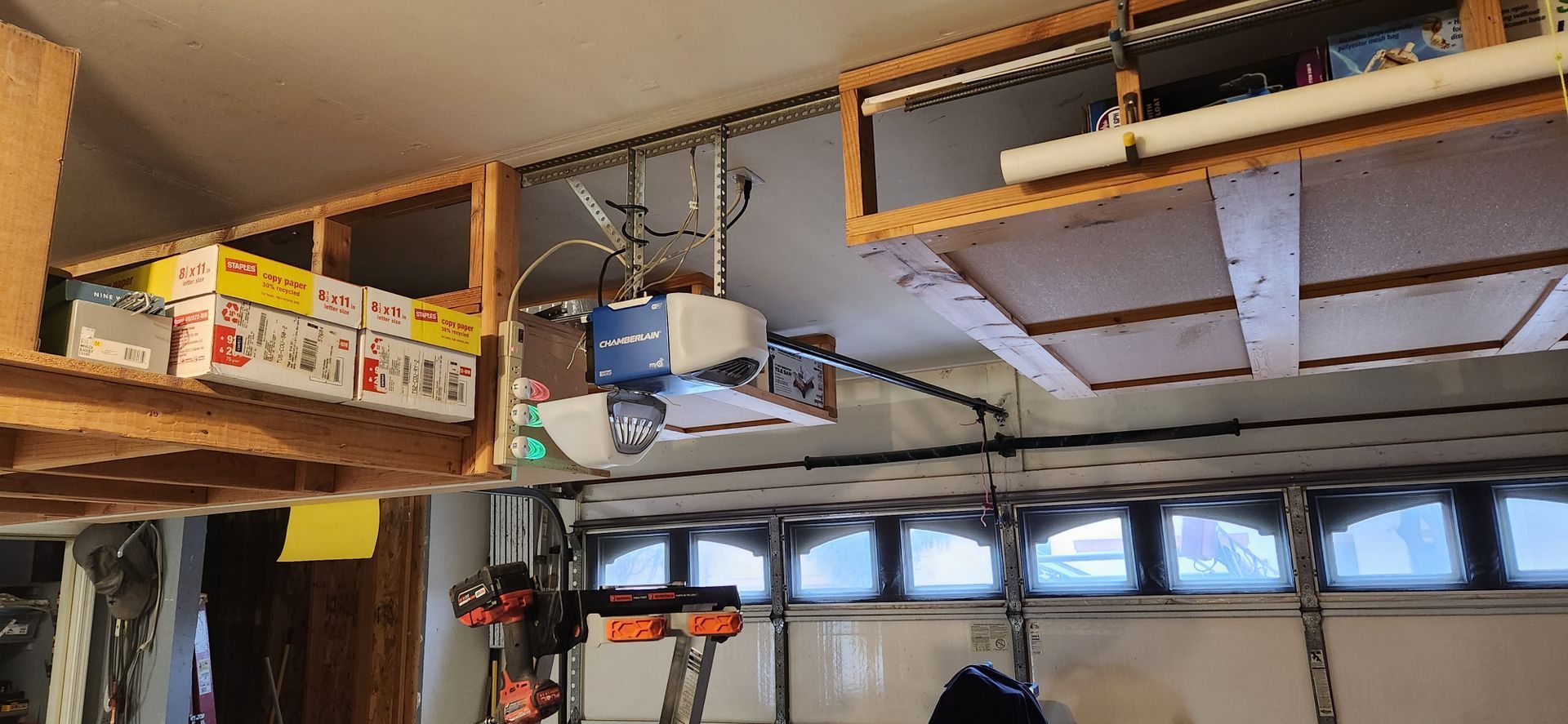 A garage with a garage door opener hanging from the ceiling.