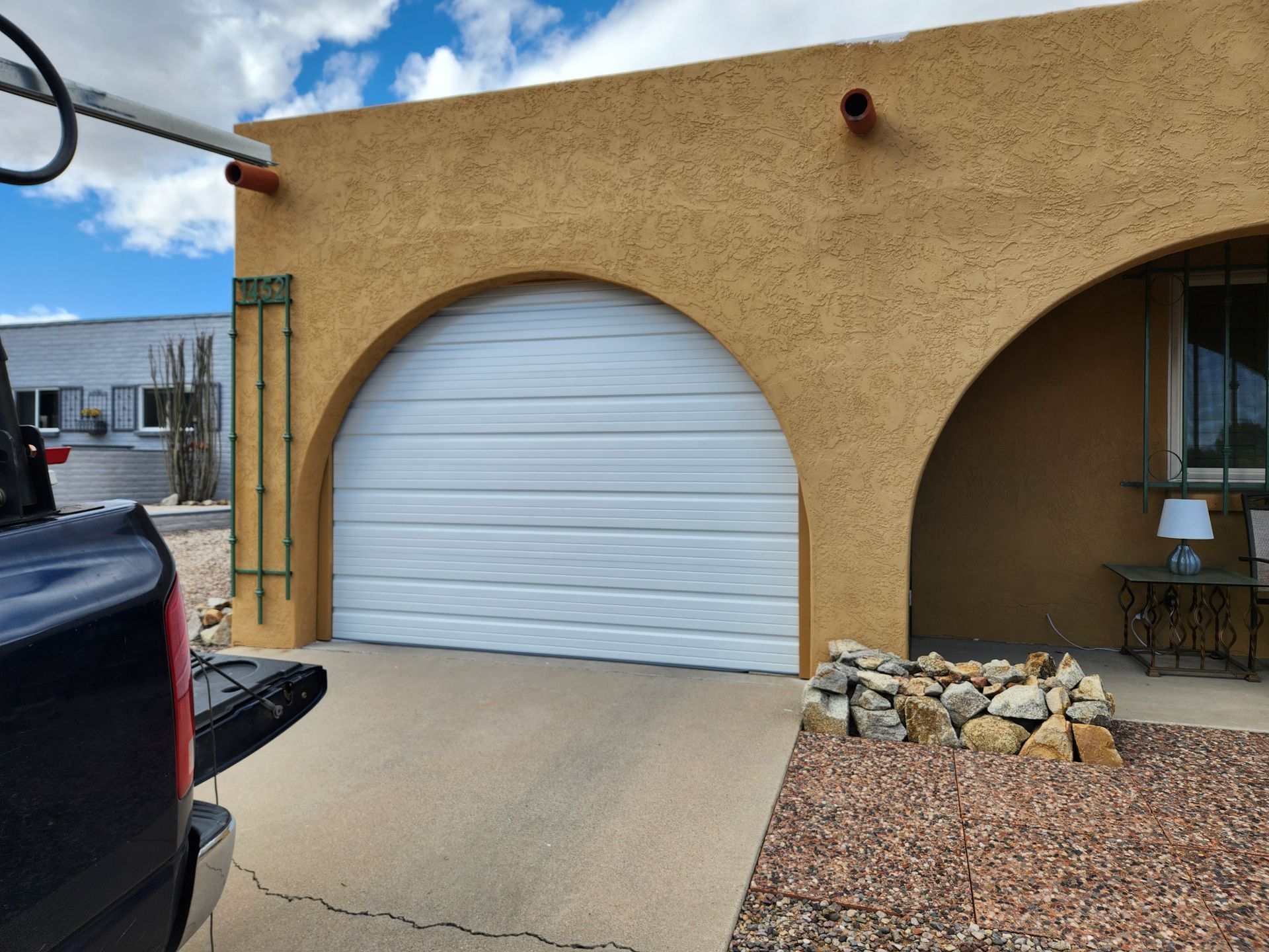 A truck is parked in front of a house with a white garage door