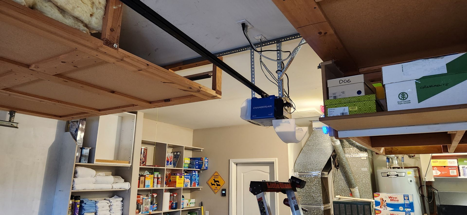 A garage with a garage door opener hanging from the ceiling.