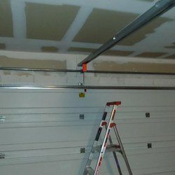 A ladder is sitting under a garage door in a garage.