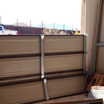 A garage door is being repaired and a truck is parked in the background.