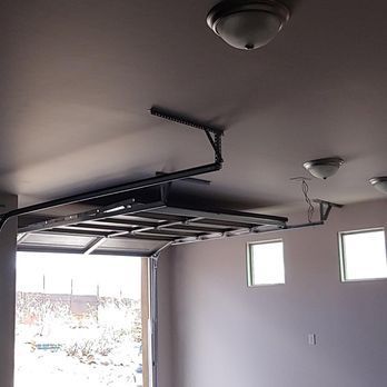 A garage with a garage door open and a ceiling light.