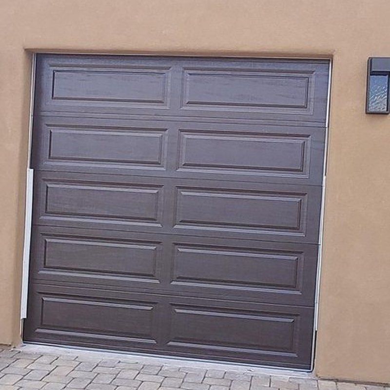 A brown garage door is against a tan wall