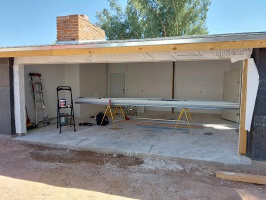 A garage is being remodeled with a ladder and a ladder.