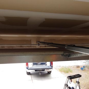 A truck is parked in a garage next to a ladder.