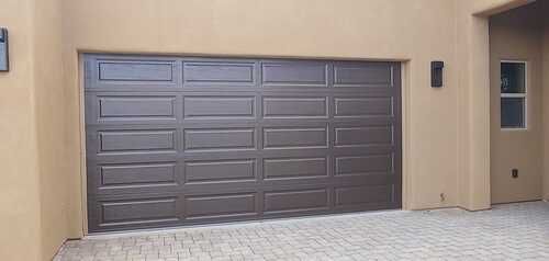 A large garage door is sitting in front of a house.