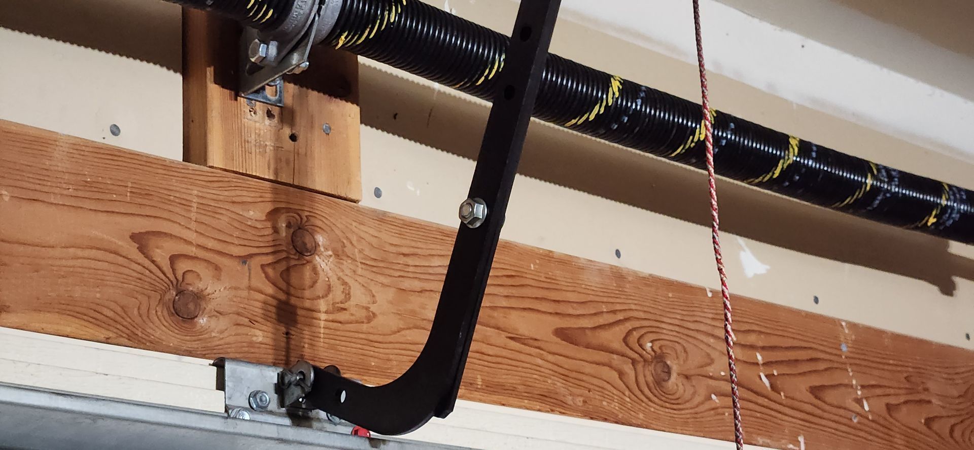 A close up of a garage door spring in a garage.