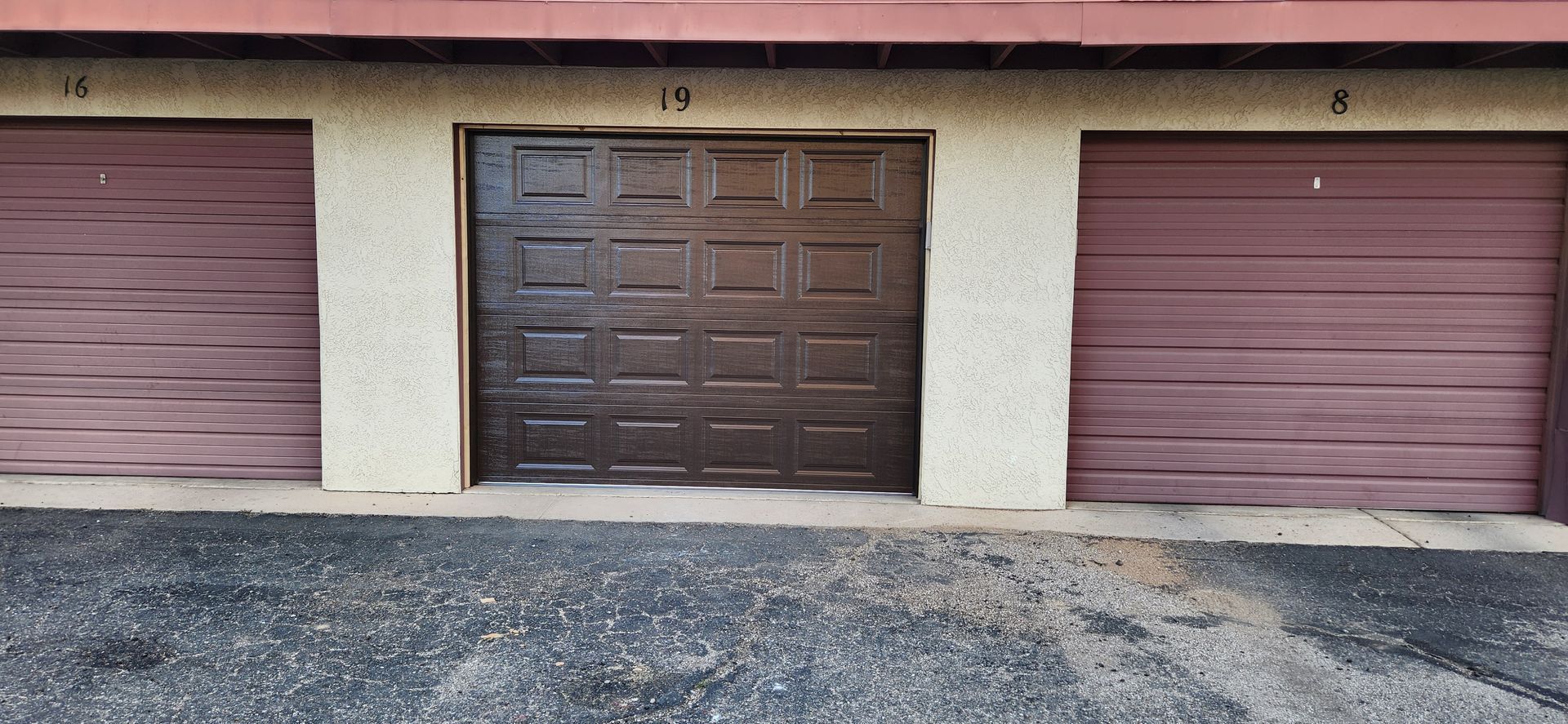 A row of garage doors are lined up next to each other on the side of a building.