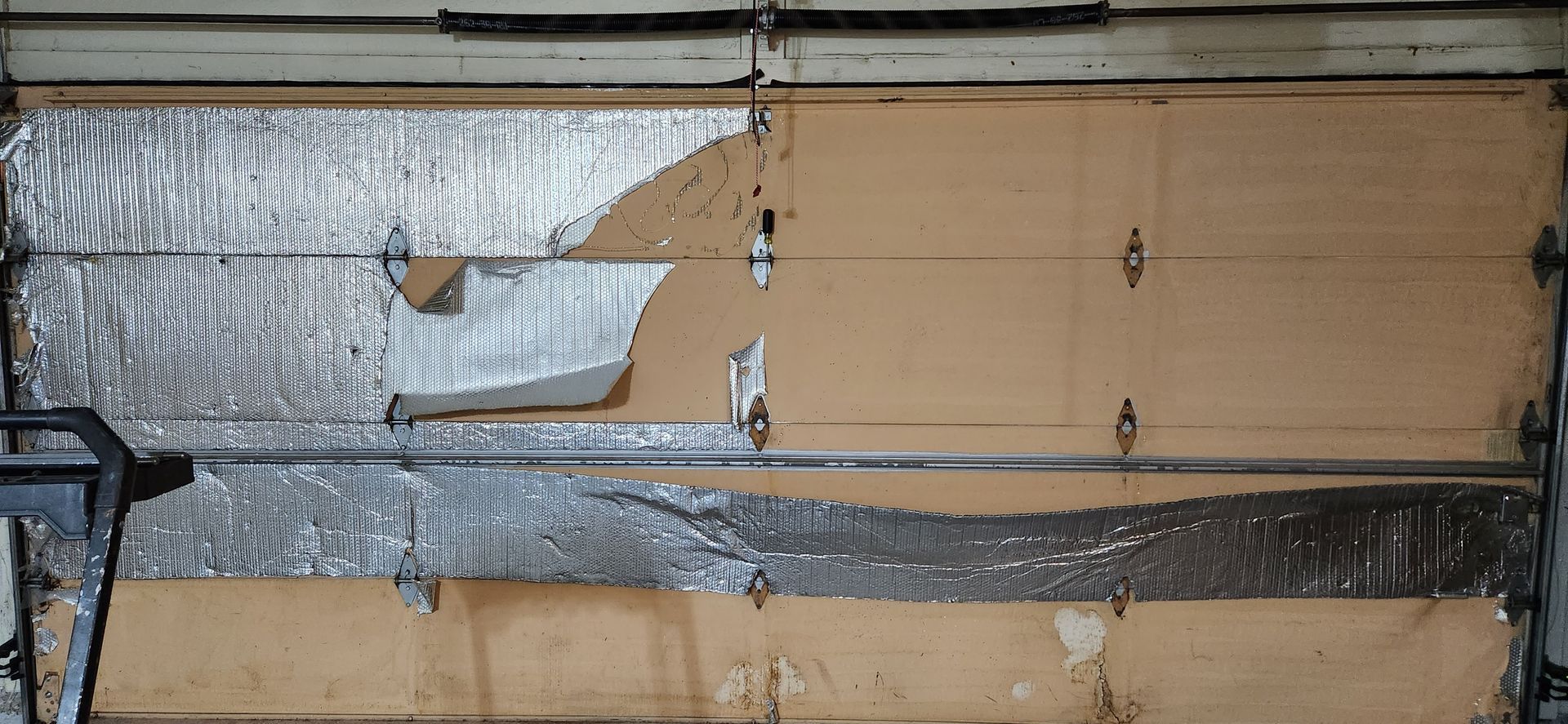 A garage door with a piece of aluminum foil on it.