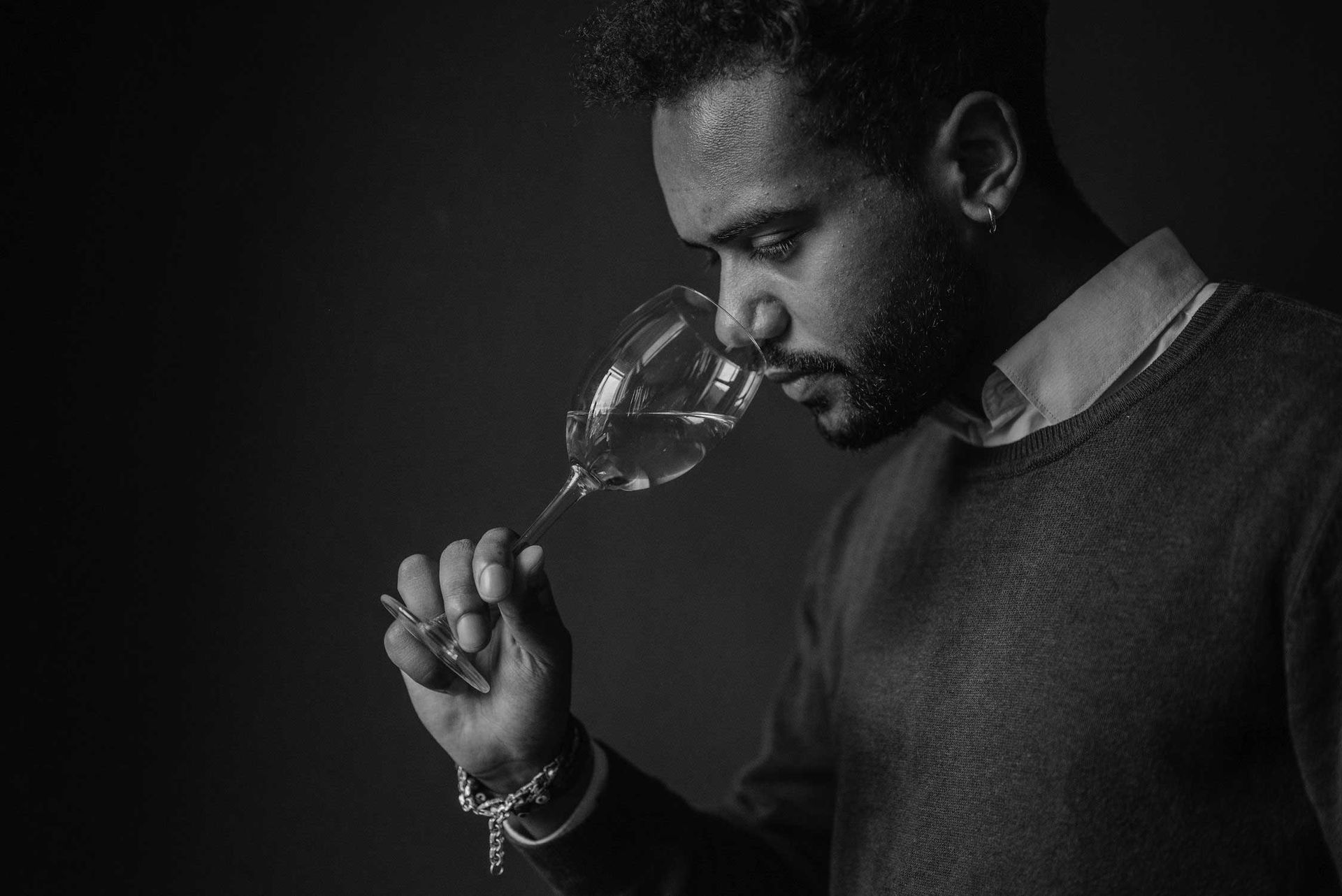 A man is smelling a glass of wine.