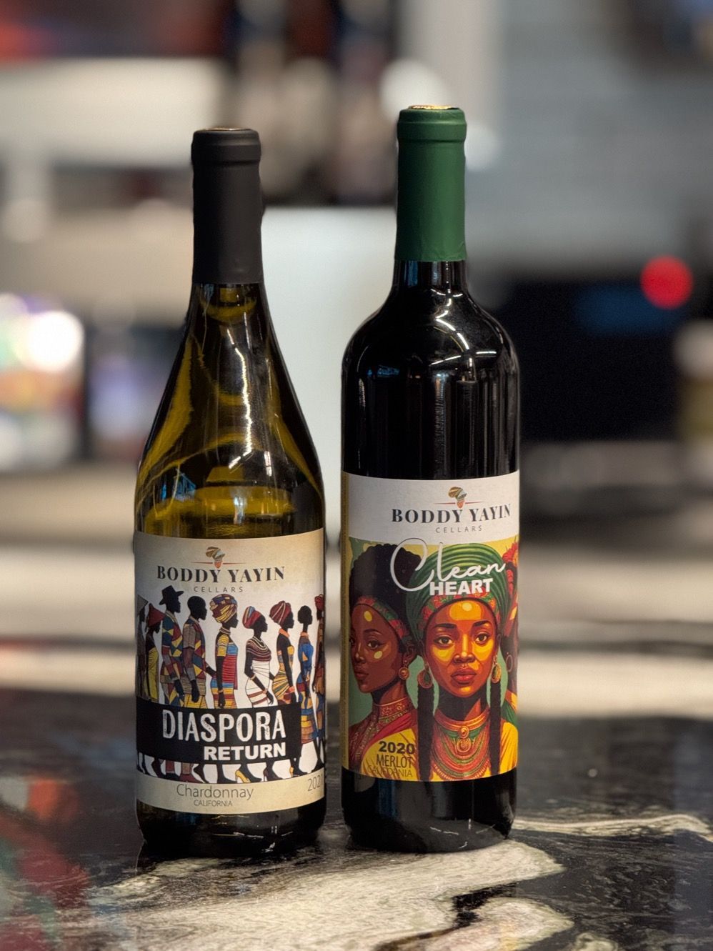 Two bottles of wine are sitting next to each other on a table.