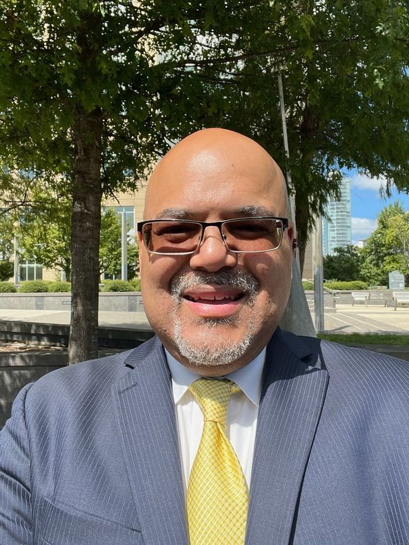 A man in a suit and tie is smiling for the camera.