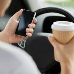 man using phone while driving the car