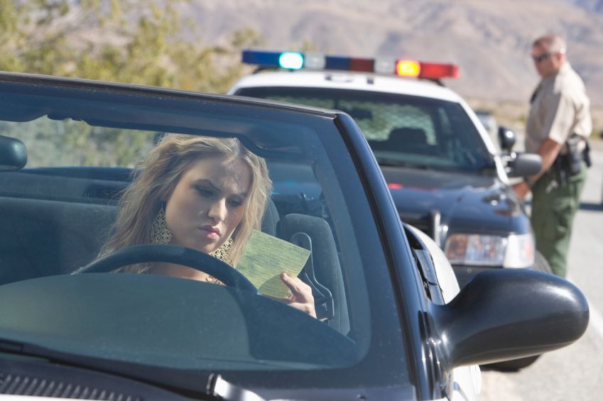 A police officer is talking to a woman in a car.