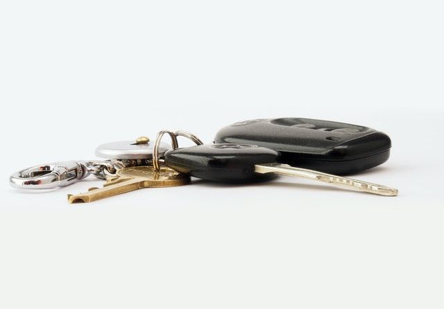 A bunch of car keys and a keychain on a white background.