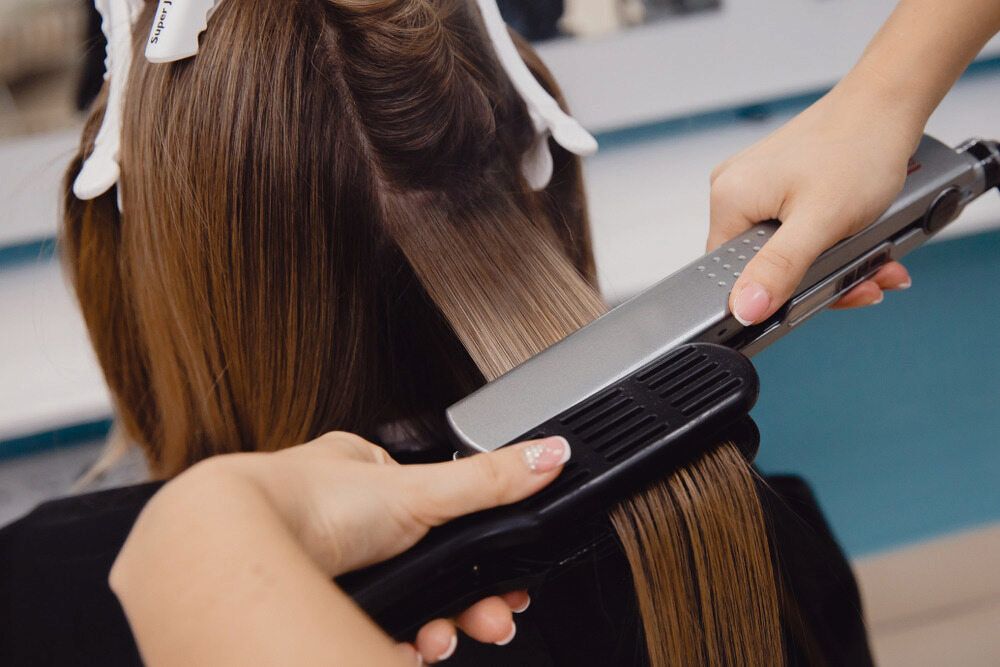 A Woman is Getting Her Hair Done by a Hairdresser in a Salon — Azure Hair in South Mackay, QLD